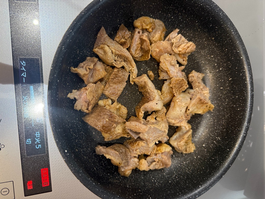 Searing tender Wagyu beef tendon in a skillet with salt and black pepper