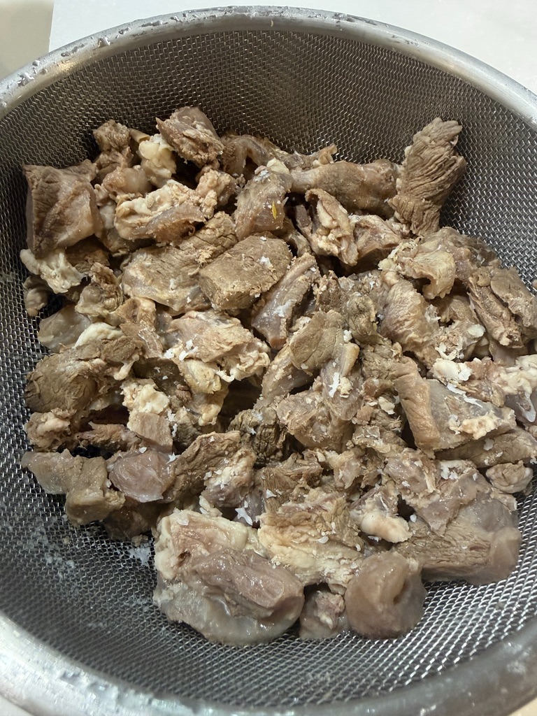 Parboiled and cleaned Kuroge Wagyu beef tendon drained in a colander